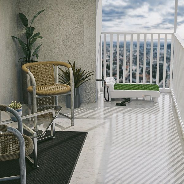 Fydoo self-cleaning dog toilet with synthetic grass installed on a modern apartment balcony with outdoor furniture.