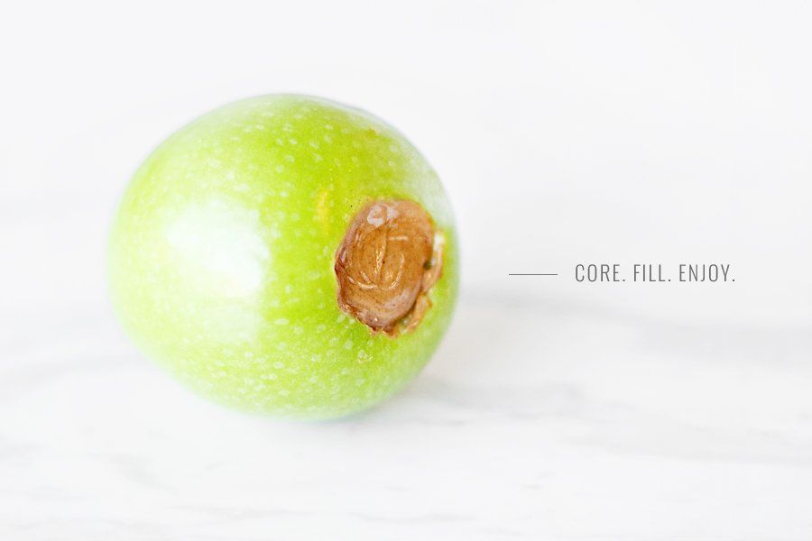 Cored green apple filled with peanut butter as a DIY edible apple Kong dog toy. Text reads: Core. Fill. Enjoy.