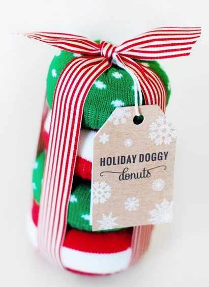 DIY festive holiday doggy donuts stacked and tied with a red striped ribbon and tag for a Christmas dog gift.