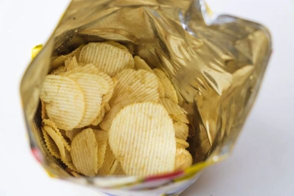 Open bag of ridged potato chips viewed from above.