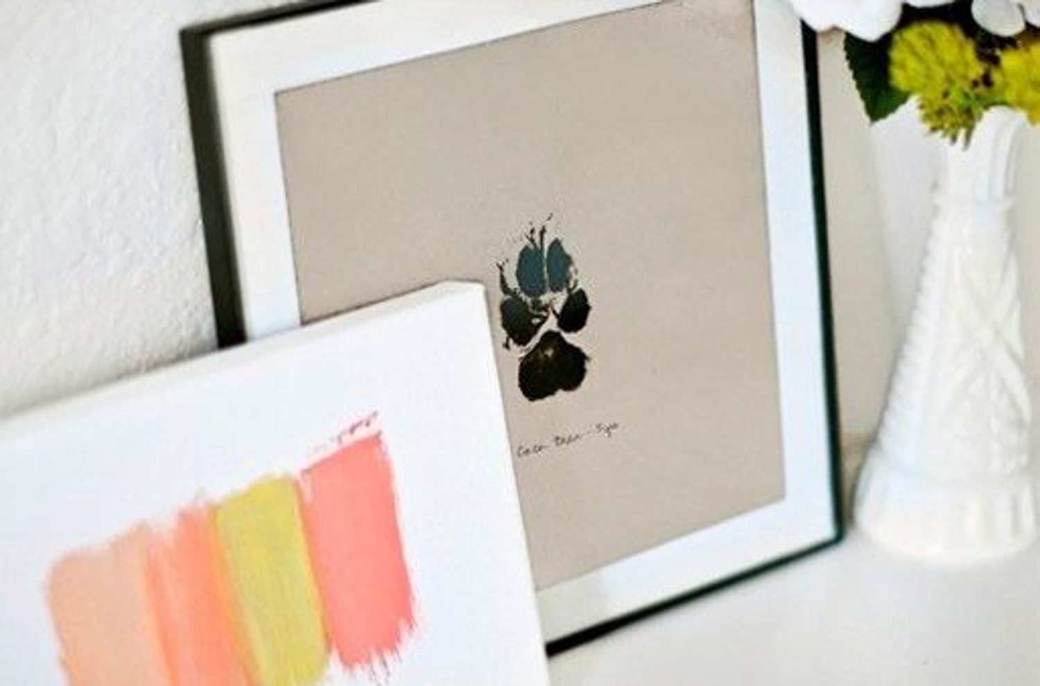 DIY paw print wall art in a simple frame on a white wall