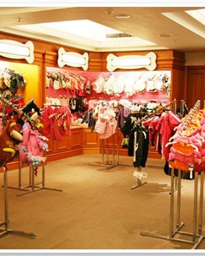 Luxury dog clothes and designer pet fashion on display racks inside the Harrods Pet Kingdom boutique.