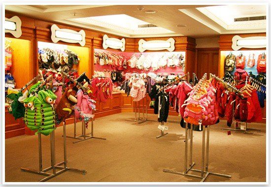 Luxury dog clothes and designer pet fashion on display racks inside the Harrods Pet Kingdom boutique.