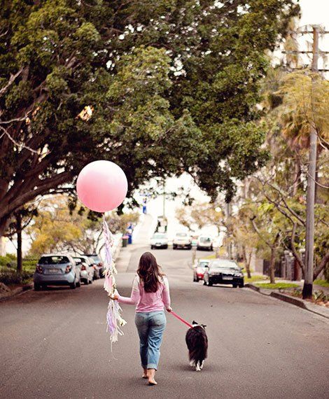 Woman walking her dog with a large pink balloon, symbolizing a farewell and new beginnings for Pretty Fluffy.