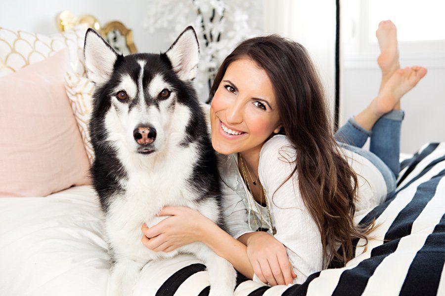 A smiling dog mum cuddling her Siberian Husky during a stylish, pet-friendly home tour.