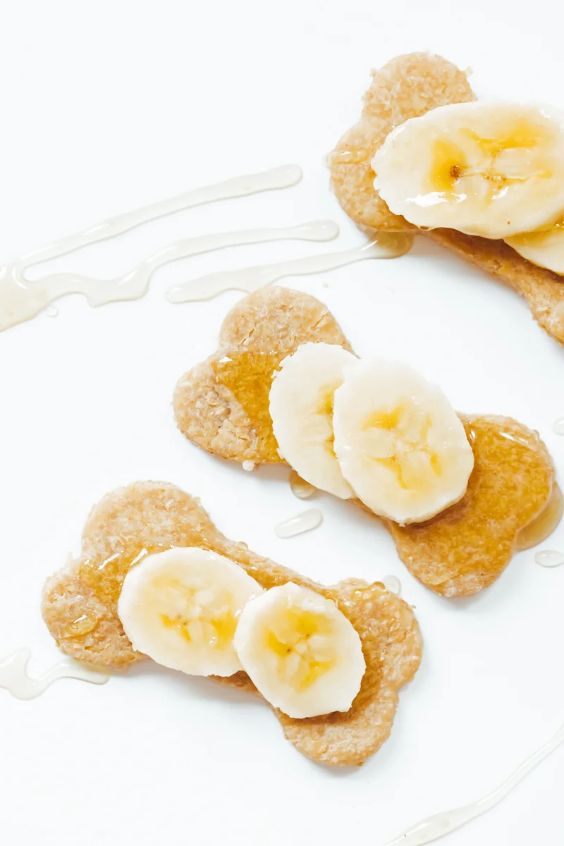 homemade peanut butter dog biscuits with sliced banana and honey drizzle