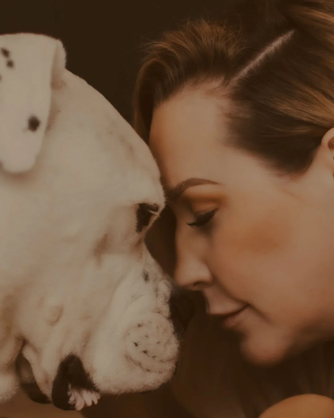 A woman nose to nose with her old dog
